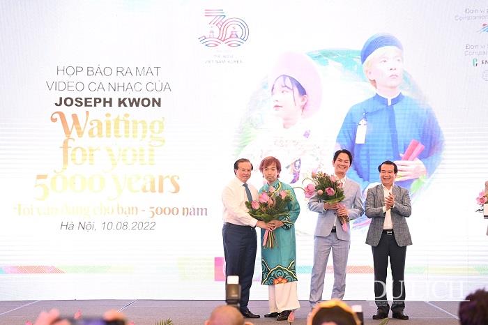Thứ trưởng Bộ Văn hóa, Thể thao và Du lịch Tạ Quang Đông, Phó Tổng cục trưởng Tổng cục Du lịch Hà Văn Siêu tặng hoa cho ca sĩ Joseph Kwon và đại diện nhà tổ chức sự kiện